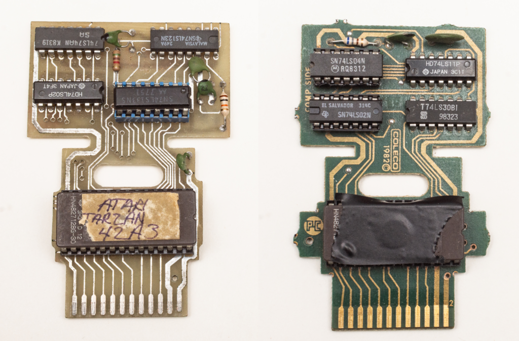 A pair of bare Atari 2600 game cartridge motherboards. One has a sticker that said Tarzan on the game ROM chip.