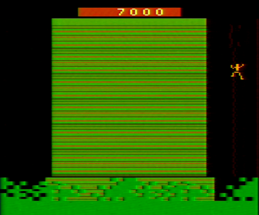 Tarzan climbs on a chain on the right side of the screen next to a cliff.