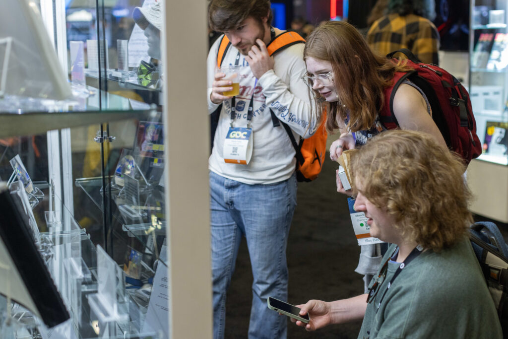 A group of people looking at a glass display case.