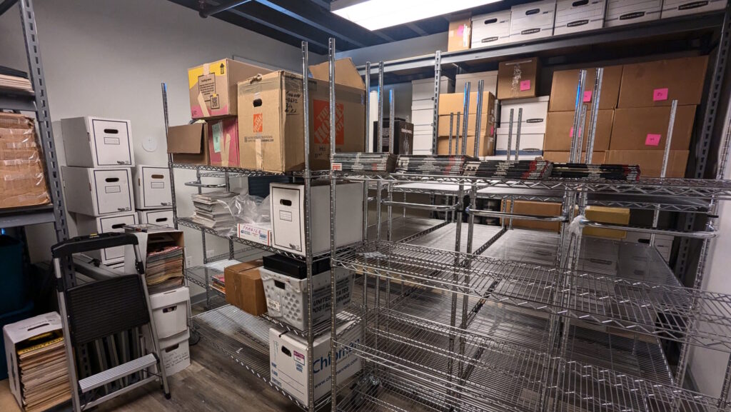 A room densely filled with metal shelves and boxes.