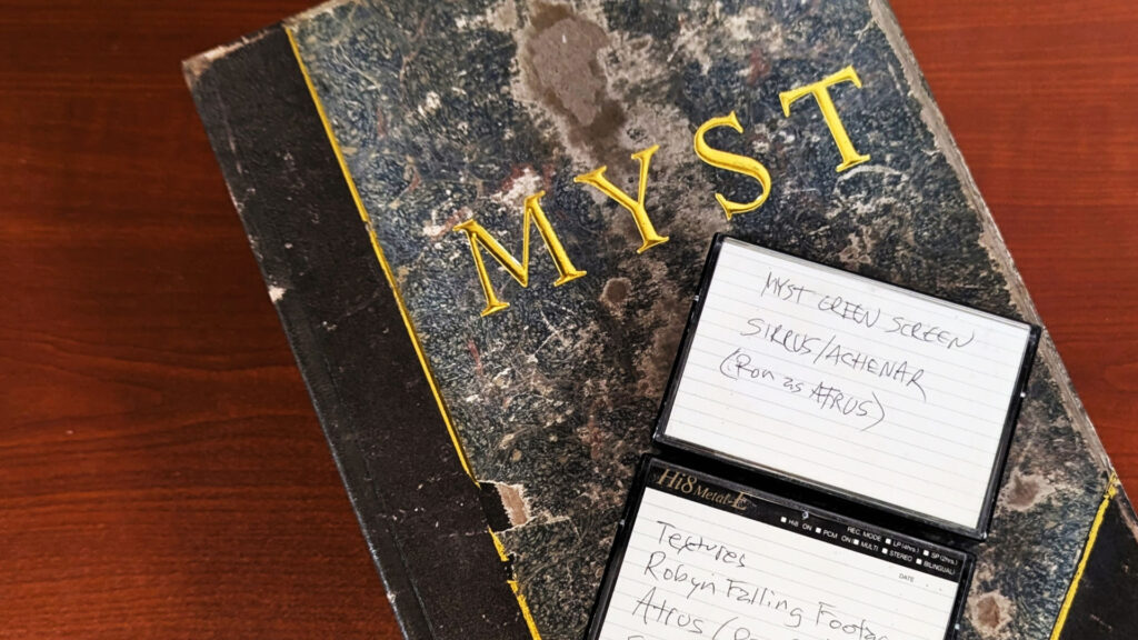 A replica of the book from Myst. On top of the book, there are two videocassettes. One of them is labeled "Myst green screen, Sirrus/Achenar (Ron as Atrus)."